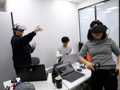 بان بوهانج مخترع منصة ألعاب اجتماعية افتراضية (على اليسار) يرتدي نظارة ميتا الافتراضية في بكين. 21 يناير 2022 - REUTERS