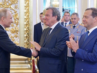 المستشار الألماني الأسبق جيرهارد شرودر يصافح الرئيس الروسي فلاديمير بوتين خلال حفل تنصيب بوتين في موسكو- 7 مايو 2018 - REUTERS