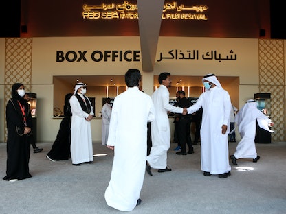 سعوديون يتجمعون أمام شباك التذاكر بإحدى دور السينما خلال النسخة الأولى من مهرجان البحر الأحمر السينمائي، قبل عرض فيلم "أبطال" في مدينة جدة السعودية، 12 ديسمبر 2021. - Red Sea Film Festival