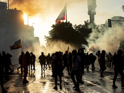 متظاهرون يشتبكون مع شرطة مكافحة الشغب خلال احتجاجات ضد حكومة الرئيس التشيلي سيباستيان بينيرا في العاصمة سانتياغو - AFP