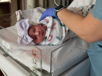 ممرضة تتحقق من المؤشرات الحيوية لطفل حديث الولادة في مستشفى بومونت بولاية ميشيجان الأميركية - 1 فبراير 2022 - REUTERS