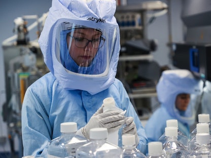 عاملة تعد المواد الخام للحمض النووي الريبوزي المرسال، وهي الخطوة الأولى في صناعة اللقاح المضاد لفيروس كورونا في مختبر شركة "بايونتيك" في ألمانيا - Bloomberg