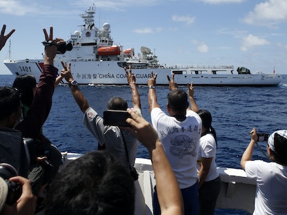 سفينة تابعة لخفر السواحل الصيني تسعى لكبح مسار سفينة إمداد حكومية فلبينية، تضمّ إعلاميين، في منطقة متنازع عليها بجزر "سبراتلي" في بحر الصين الجنوبي- 29 مارس 2014 - REUTERS