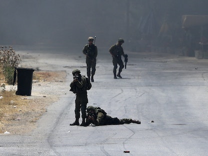 جنود إسرائيليون في مواجهات مع متظاهرين فلسطينيين بالضفة الغربية - 11 يونيو 2021 - AFP