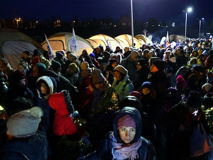 الفارون من الغزو الروسي لأوكرانيا ينتظرون حافلة بعد عبور الحدود من أوكرانيا إلى بولندا - 7 مارس 2022 - REUTERS