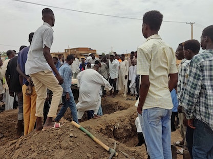 سودانيون يجتمعون لدفن الضحايا الذين قتلوا في قصف مدفعي جنوب العاصمة السودانية الخرطوم- 11 يونيو 2023 - AFP