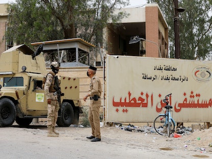عناصر من قوات الأمن العراقية يقفون في حراسة المدخل الرئيسي لمستشفى ابن الخطيب في بغداد. 26 أبريل 2021 - REUTERS