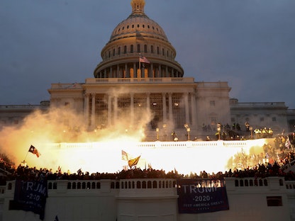 وميض ناجم عن انفجار ذخيرة للشرطة أثناء تجمع أنصار الرئيس الأميركي السابق دونالد ترمب أمام مبنى الكابيتول في واشنطن. 6 يناير 2021 - REUTERS