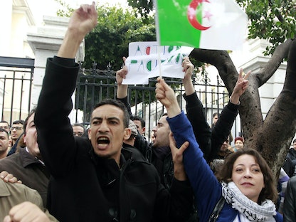 أميرة بوراوي (الأولى لليمين) زعيمة حركة بركات (كفى) ترفع العلم الجزائري خلال مظاهرة في الجزائر العاصمة. 15 مارس 2014 - REUTERS