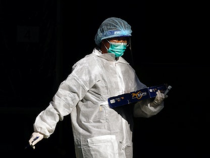 عامل طبي يرتدي سترة واقية في مركز اختبار مؤقت لمرضى فيروس كورونا في هونغ كونغ، 30 نوفمبر 2020 - REUTERS