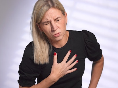 امرأة يبدو أنها تعاني مشكلات مرتبطة بالقلب والصدر. - Getty Images