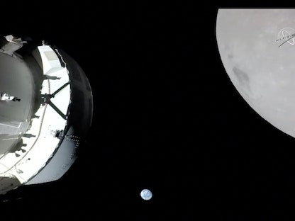 كاميرا على جناح المصفوفة الشمسية في Orion تلتقط مشهداً للمركبة الفضائية والأرض والقمر أثناء تحليق الكبسولة باتجاه القمر. 21 نوفمبر 2022 - via REUTERS
