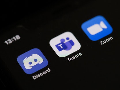 شعارات تطبيقات "زووم" و"تيمز" و"ديسكورد" على شاشة هاتف ذكي - AFP