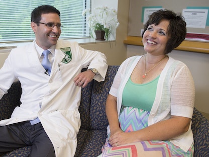 الدكتور كريستيان هينريكس، الباحث في مركز أبحاث السرطان إلى جانب مريضته أريكا والاس، التي تعافت من شكل نادر من سرطان عنق الرحم، ماريلاند، الولايات المتحدة، 29 مايو 2014 - AFP
