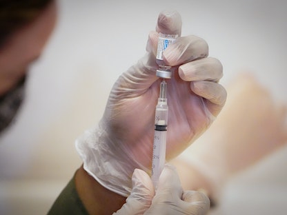 عامل طبي في أحد مراكز التطعيم بولاية مانهاتن الأميركية يقوم بتحضير جرعة من لقاح "جونسون أند جونسون"، 12 مايو 2021 - REUTERS