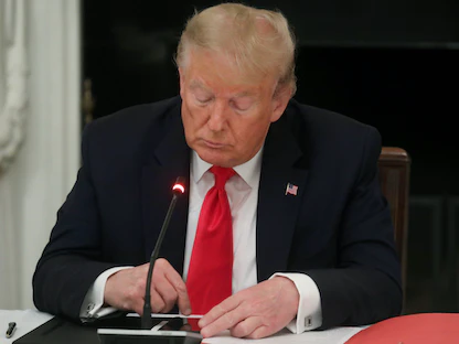 الرئيس الأميركي السابق دونالد ترامب ينقر على شاشة الهاتف المحمول خلال لقاء بالبيت الأبيض - 18 يونيو 2020 - REUTERS