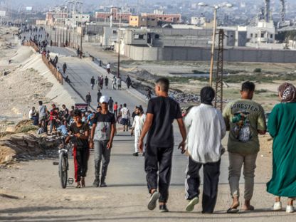 فلسطينيون على شاطئ بالقرب من وادي غزة في مدينة غزة. 22 مايو 2024 - AFP