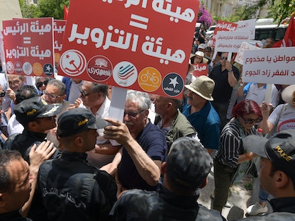 الشرطة تحاول منع متظاهرين من التوجه لمقر الهيئة الانتخابية "ISIE" خلال مسيرة ضد الرئيس، تونس - 4 يونيو 2022. - AFP
