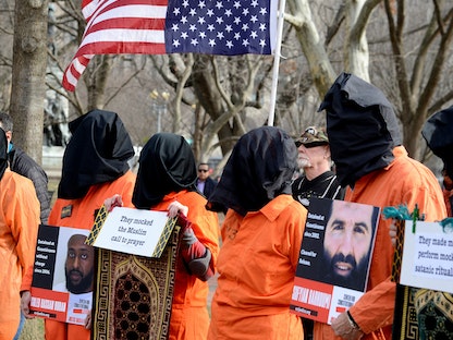 نشطاء يرتدون زي السجناء في مظاهرة تطالب بإغلاق معتقل غوانتانامو ومحاسبة المتورطين في التعذيب، واشنطن، 11 يناير 2020 - REUTERS