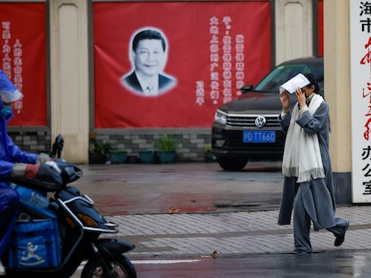 صورة الرئيس الصيني شي جين بينغ معلقة في شارع أمام المؤتمر الوطني لنواب الشعب الصيني في شنغهاي. - REUTERS