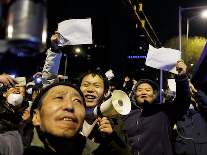 صينيون يرفعون أوراقاً بيضاء احتجاجاً على قيود كورونا وإحياءً لذكرى ضحايا حريق أورومتشي في غرب البلاد، بكين – 28 نوفمبر 2022 - REUTERS
