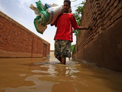 شاب سوداني يسير وسط مياه الفيضانات في 3 سبتمبر 2020 - AFP