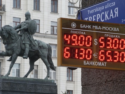 لوحة تعرض أسعار صرف العملات أمام نصب تذكاري للأمير يوري دولجوروكي في موسكو - 1 ديسمبر 2014 - REUTERS