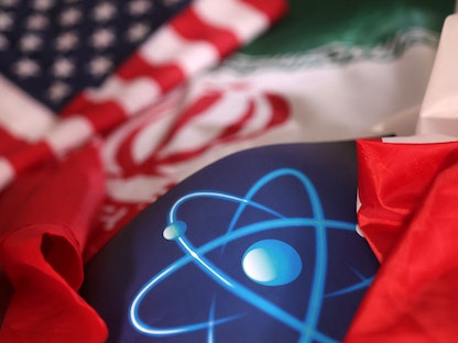 رسم يتضمن علم إيران وعلم الولايات المتحدة إضافة إلى شعار الوكالة الدولية للطاقة الذرية. - REUTERS