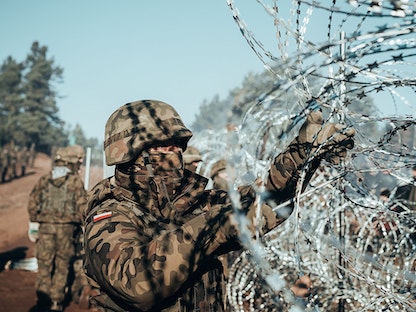 جندي بولندي ينصب أسلاكاً شائكة على الحدود مع بيلاروسيا حيث يتكدس آلاف المهاجرين - 9 نوفمبر 2021 - via REUTERS