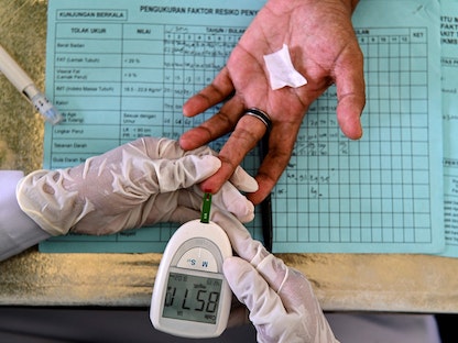 امرأة مسنة تخضع لفحوصات ارتفاع ضغط الدم والكوليسترول والسكري في إندونيسيا - 15 ديسمبر 2021 - AFP