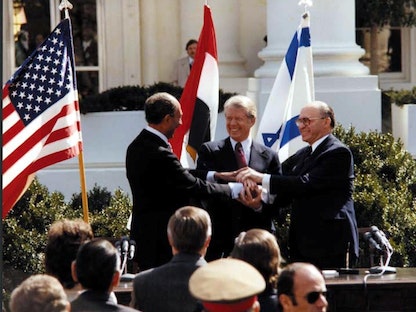 الرئيس الأميركي جيمي كارتر والرئيس المصري أنور السادات ورئيس الوزراء الإسرائيلي مناحم بيجن أثناء الاحتفال بتوقيع معاهدة السلام - 26 مارس 1979 - REUTERS