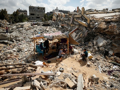 فلسطينيون يجلسون في خيام وسط أنقاض منازلهم التي دمرتها الغارات الجوية الإسرائيلية في غزة-23 مايو 2021 - REUTERS