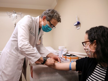طبيب يجهز مريضة بالتصلب المتعدد لتلقي الدواء في نيويورك بالولايات المتحدة. 1 مايو 2020 - REUTERS