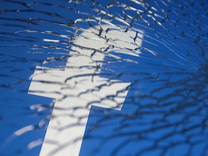 شعار فيسبوك مطبوع على زجاج مكسور - REUTERS