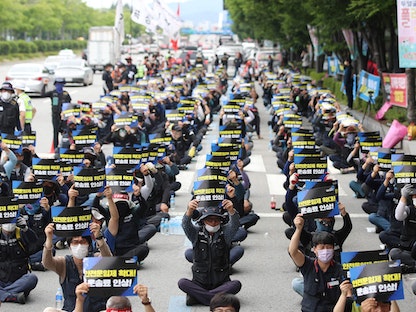 عمال ينظمون مسيرة أمام مصنع "كيا موتورز" في مدينة جوانجو. كوريا الجنوبية 10 يونيو 2022 - AFP