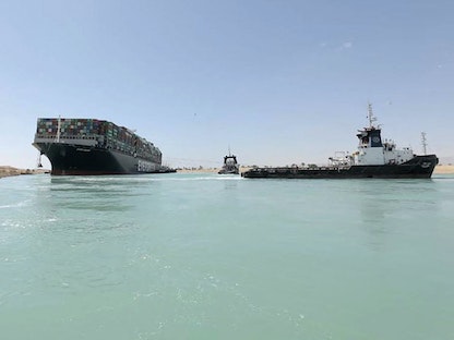 زورق يسحب سفينة "إيفر غيفن" بعد تعويمها بالكامل عن ضفاف قناة السويس - 29 مارس 2021 - AFP