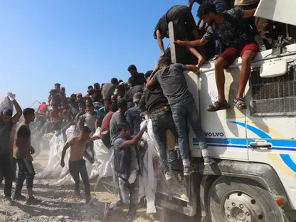 رجل فلسطيني يحمل مساعدات دخلت غزة بينما يركب فلسطينيون آخرون شاحنة، في بيت لاهيا شمال قطاع غزة. 3 أغسطس 2025 - Reuters