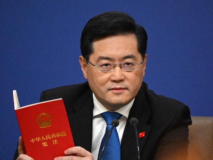 وزير الخارجية الصيني السابق تشين جانج يمسك بنسخة من الدستور خلال جلسة للبرلمان في بكين. 7مارس 2023 - AFP