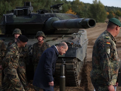 المستشار الألماني أولاف شولتز بجوار دبابة من طراز "ليوبارد 2" أثناء زيارة لقوات الجيش الألماني خلال مناورات تدريبية في أوستينهولتس شمالي ألمانيا- 17 أكتوبر 2022 - AFP
