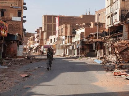 أحد عناصر الجيش السوداني يسير بين المباني المتضررة من النزاع مع قوات الدعم السريع في أم درمان. 7 أبريل 2024 - REUTERS