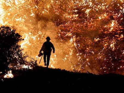 رجل إطفاء يعمل على إطفاء الحرائق التي نشبت في كاليفورنيا - REUTERS