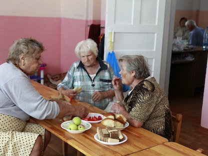 أشخاص كبار في السن يتناولون وجبة جماعية في كراسنودار، جنوب روسيا- 8 يوليو 2012 - REUTERS