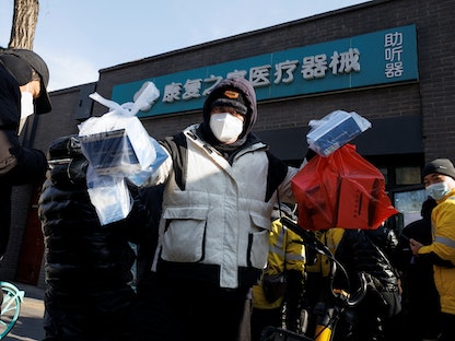سائق توصيل يأخذ الدواء من صيدلية في بكين وسط استمرار تفشي فيروس كورونا. 7 ديسمبر 2022 - REUTERS