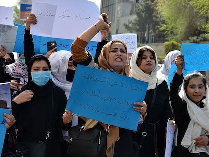 نساء وفتيات أفغانيات يشاركن في احتجاج أمام وزارة التربية والتعليم في كابول 26 مارس 2022 - AFP