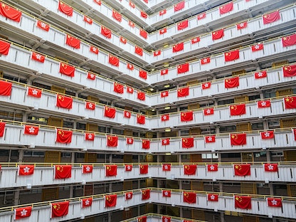 أعلام الصين وهونج كونج تتدلّى من مبنى سكني في الذكرى الخامسة والعشرين لعودة المدينة إلى الحكم الصيني - 26 يونيو 2022 - REUTERS