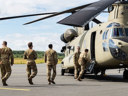 جنود أميركيون يقتربون من مروحية "شينوك" خلال تدريبات مشتركة مع الجيش الفنلندي في مدينة بيركالا الفنلندية. 3 أغسطس 2022 - Bloomberg