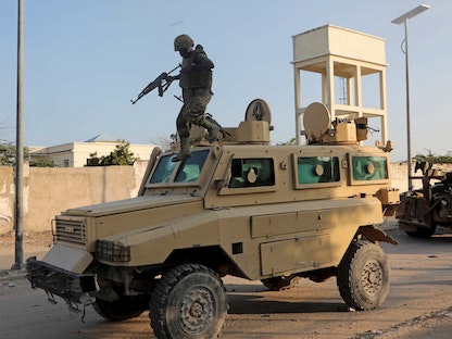 جندي في بعثة الاتحاد الإفريقي بالصومال (أميصوم) يقفز من مركبة عسكرية بالقرب من موقع تفجير استهدف قافلة تابعة لقوات الاتحاد الإفريقي في مقديشو، الصومال - 11 نوفمبر 2020. - REUTERS