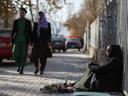 هادية أحمدي، 43 عاماً، معلمة في ظل الحكومة الأفغانية السابقة، لكنها فقدت وظيفتها بسبب القيود المفروضة على عمل النساء، والآن تقوم بتلميع الأحذية في كابول، أفغانستان. 22 نوفمبر 2021. - REUTERS