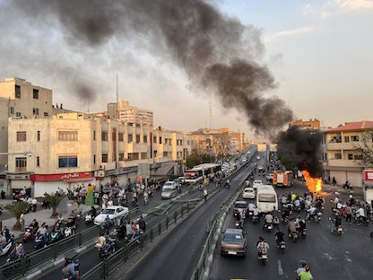 دراجة نارية مشتعلة في العاصمة طهران خلال موجة الاحتجاجات التي تشهدها إيران. 8 أكتوبر 2022 - AFP