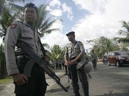 رجال شرطة يحرسون شارعاً في تيميكا بمقاطعة بابوا الإندونيسية. 16 ديسمبر 2009 - REUTERS
